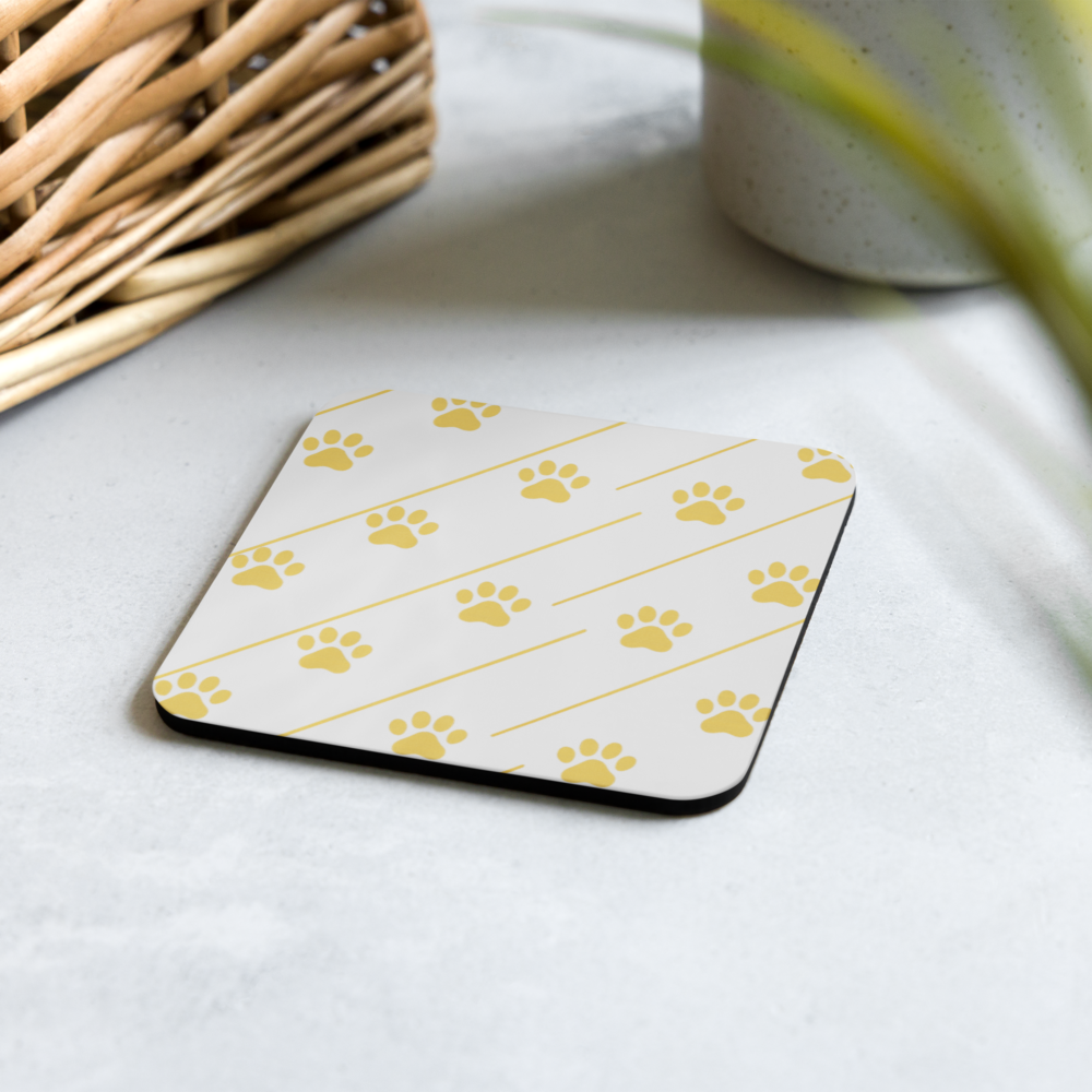 Coaster with gold paw prints on a white surface