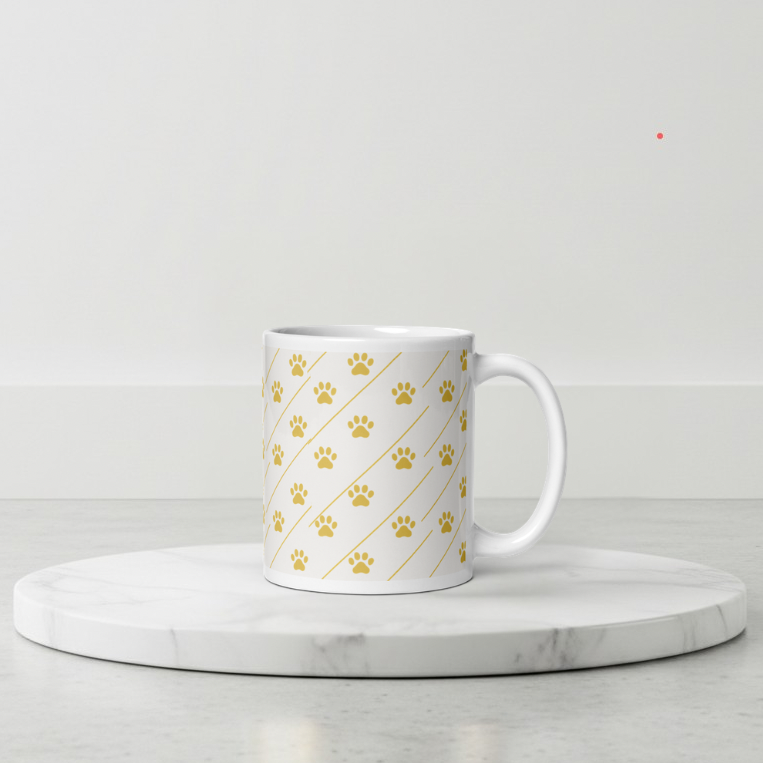 Ivory Whisper mug with gold paw print pattern on a marble coaster with a light gray background