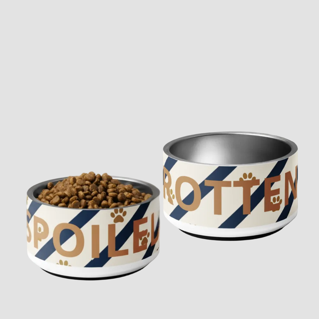 Two dog bowls with 'Spoiled' and 'Rotten' text on a marble surface.