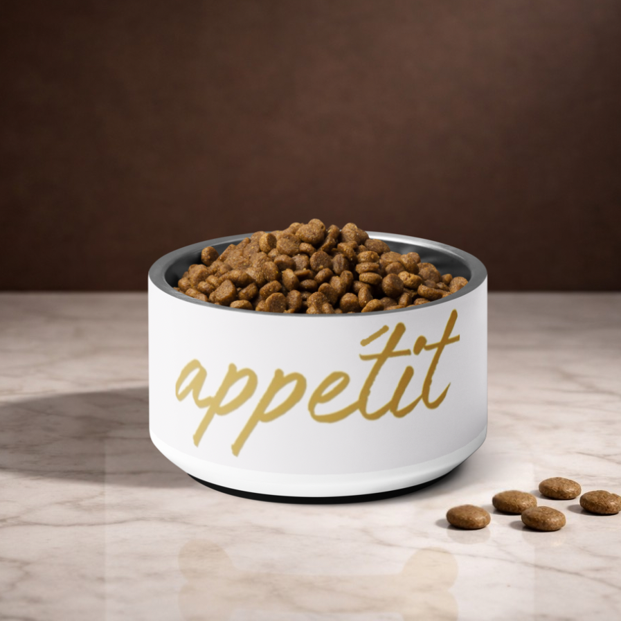 White bowl with 'appétit' text filled with dog food on a wooden surface.