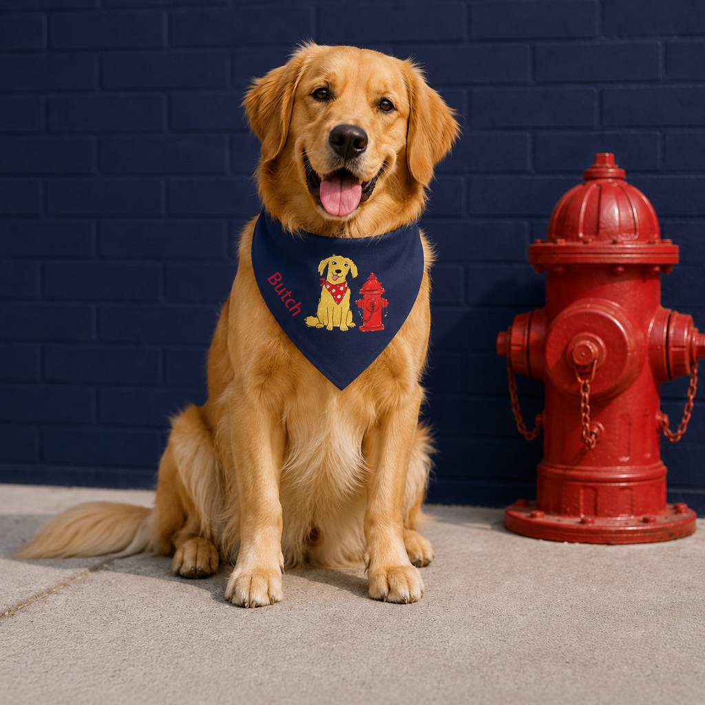 Large dog wearing a bandana with a fire hydrant design next to a red fire hydrant against a blue brick wall. 