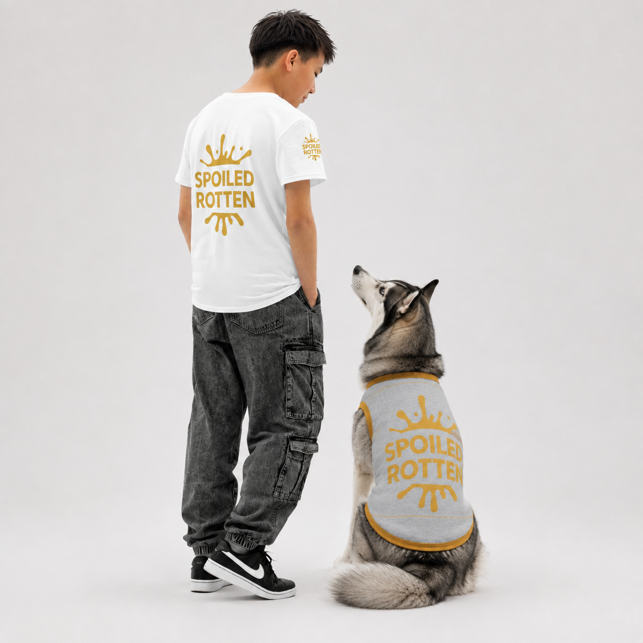 A boy and a dog are shown wearing matching gold  'SPOILED ROTTEN' graphic on t-shite and dog sweater.