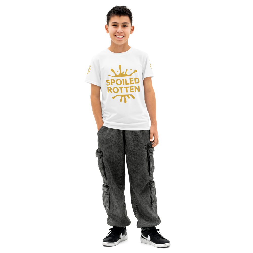 A young boy against a solid white background wearing a premium white crewneck t-shirt with a gold 'SPOILED ROTTEN' graphic.