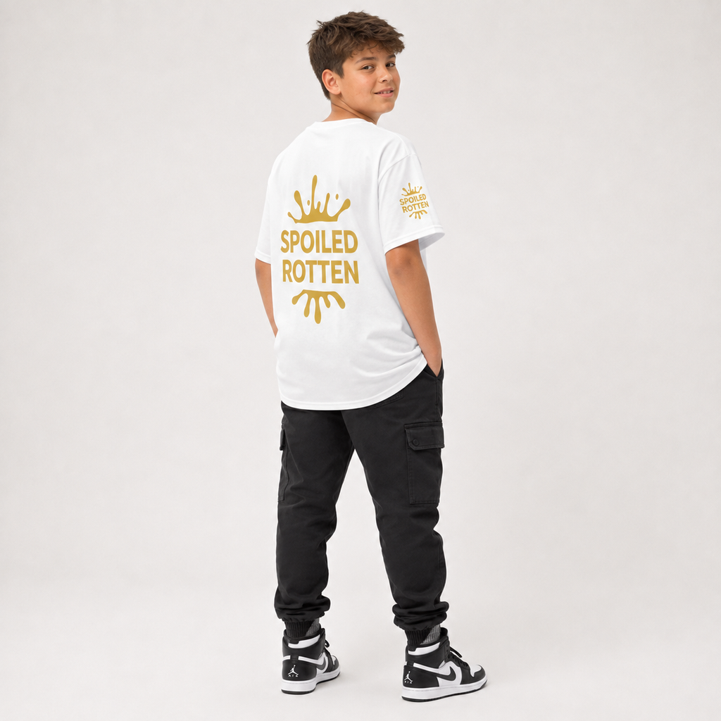 A boy modeling a unique white t-shirt from the back, with a gold splash graphic and the text 'SPOILED ROTTEN'. against a light gray studio background.