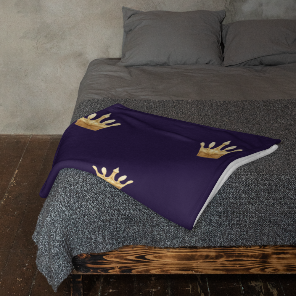 Deep Navy blanket with gold crowns on a bed with gray bedding.