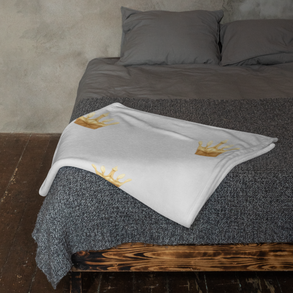 Gray textured blanket with embroidered designs on a wooden bed frame.