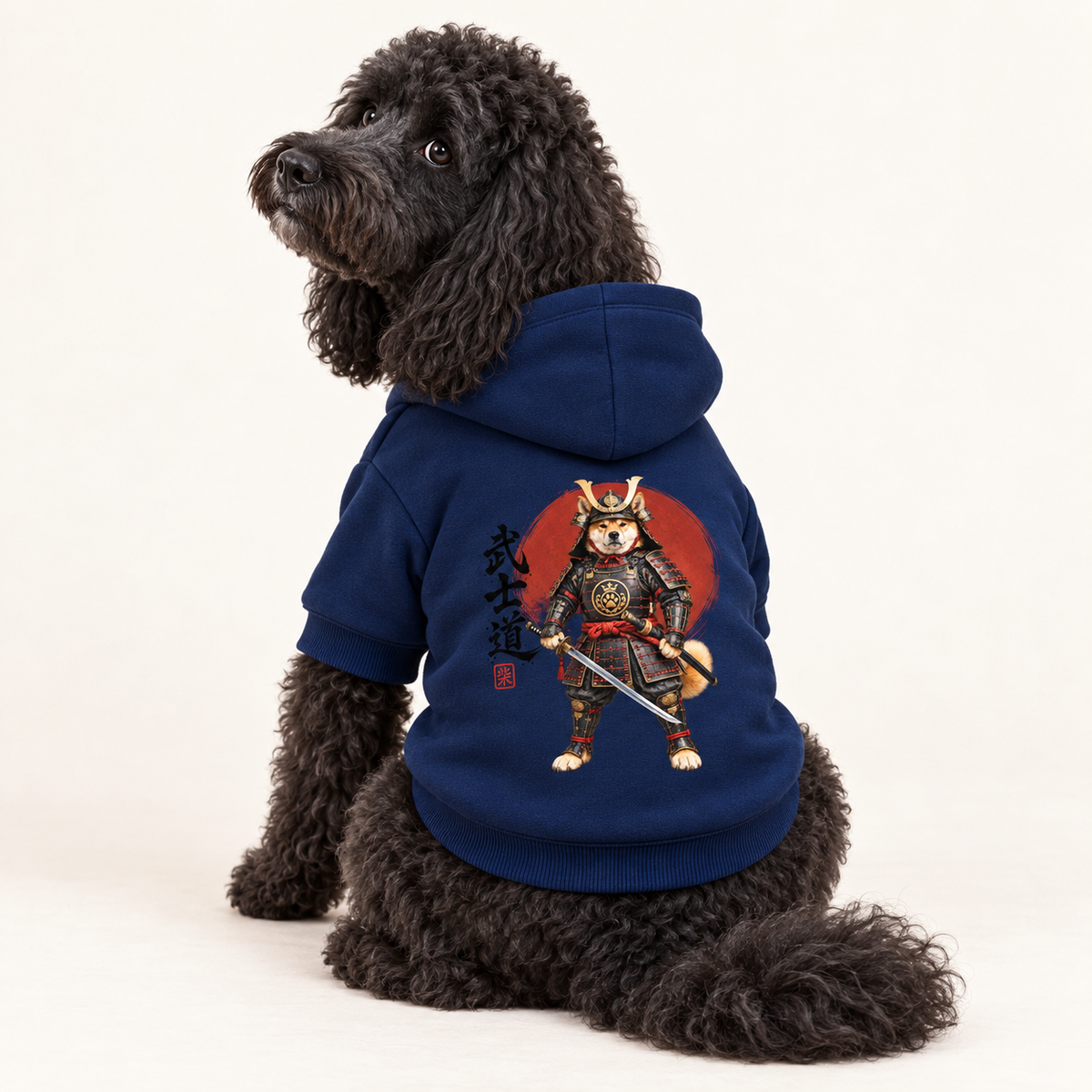 A black poodle wearing a navy blue dog hoodie with a samurai dog graphic and Japanese calligraphy on the back, by Uncommon Canine Couture Co.