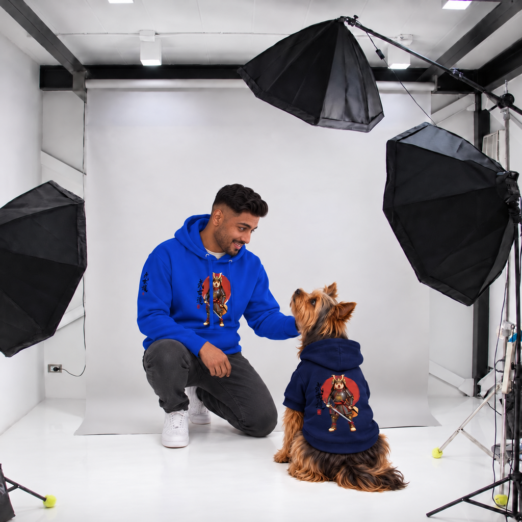 Man wearing a blue Warrior’s Way Samurai unisex hoodie kneels beside a Yorkie wearing the matching navy dog hoodie, showing both product designs.