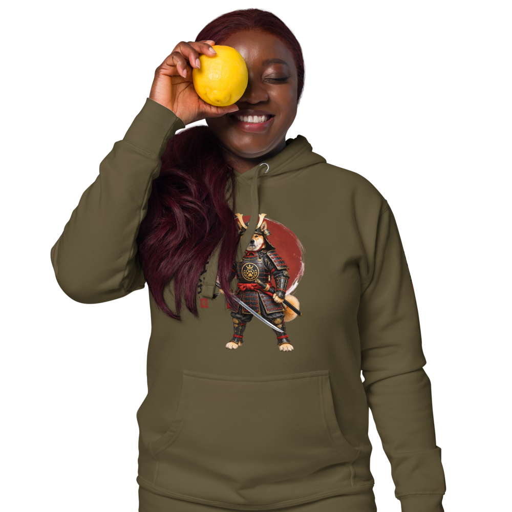 A woman wearing an hoodie with a graphic print of a samurai dog character, holding a yellow lemon to her eye.