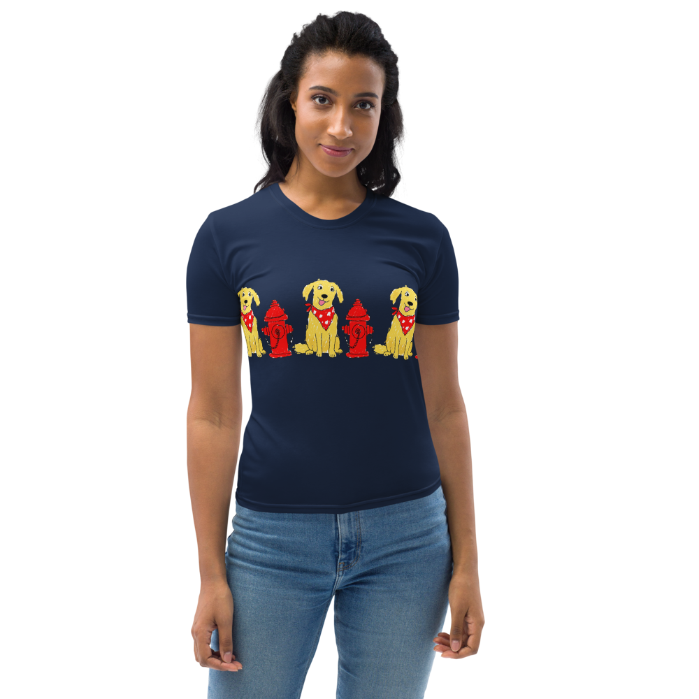 Small woman wearing a navy t-shirt with a  print of dogs wearing red bandanas next to red fire hydrants.